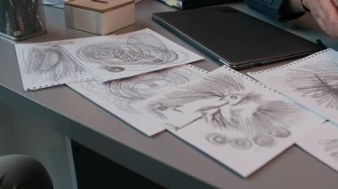 Masada yatan birden fazla korkunç çizimin yakın çekimi, çocuk psikoloğu terapi seansı sırasında çocuğun ailesine resim gösteriyor, çocukluk endişesi ve travma sorunu