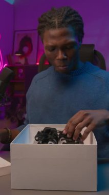 Canlı yayın sırasında spor ayakkabıları ile mutlu, canlı siyah blog yazarı açılış kutusunun dikey UGC görüntüsü, tabanı kontrol etmek, moda tasarımı övmek, kameraya bakarken