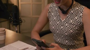 Kendine güvenen, zarif, genç Koreli kadın podcaster 'ın yakın plan çekimleri canlı yayında akıllı telefondan abone sorularını okuyup önemli konularda fikrini dile getiriyor.