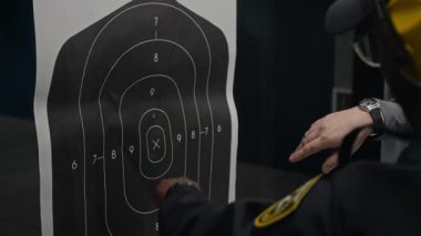 Gövde üzerindeki kurşun izlerini tartışan ve işaret eden çok ırklı polis memurunun ve atış eğitmeninin tanınamaz hale gelmiş elleri.