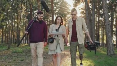 Bacak protezli profesyonel kameraman ve çekim ekibi kameraya doğru yürüyorlar ve çekim için senaryo tartışıyorlar.