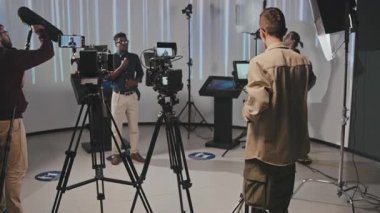 Erkek operatörün bacak protezi ile birlikte stüdyoda çalışan Afrikalı Amerikalı erkek modelle telsiz konuşmasının orta boy dikiz görüntüsü.