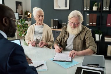 Finans müdürüyle görüşürken kıdemli bir adam sözleşme imzaladı.