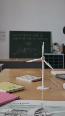 Dikey olarak hiç kimse orta okuldaki yenilenebilir enerji dersine hazırlanan küçük beyaz plastik rüzgar türbini modeli ve masasında motor konfigürasyonu olan bir poster çekmedi.