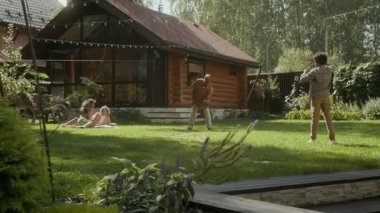 Afrika kökenli Amerikalı bir babanın genç oğluyla dışarıda, banliyö aile evinin yeşil çimlerinde beyzbol oynaması top atması, baba tutması, anne ve kız kardeşin battaniyede dinlenmesi.