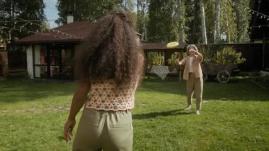 Orta boy, Afrika kökenli Amerikalı genç bir kızın örgü örüp beyaz bir anneyle uçan disk oyunu oynaması, fırlatması, yakalaması, diski düşürmesi ve sonra da onu almak için koşması.