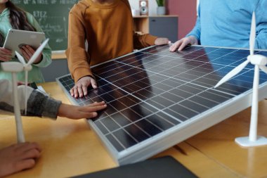 Sınıfta güneş panelleri ve rüzgar türbinlerini inceleyen öğrenciler yenilenebilir enerji kaynaklarını öğreniyorlar. Eğitim araçları ve sürdürülebilirlik anlayışını geliştiren teknoloji