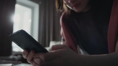 Sıkıntılı genç beyaz kızın ellerini ve yüzünü yakınlaştırmak akıllı telefonda çılgınca mesajlar yazmak, cevap beklemek, tırnaklarını yemek, online tacizcilerle veya sahtekârlarla iletişim kurmak...
