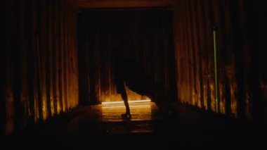 Sokak kıyafetleri içindeki genç B-Boy 'un, titreşimli lambaların altında dans ederken yaratıcı hareketler yaparken tam bir yavaş çekimi.