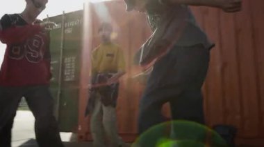 Parlak güneşli bir günde dışarı çıkmanın keyfini çıkaran şık sokak kıyafetleri içindeki yetenekli beyaz erkek zoomerların el kamerasıyla çekilmiş fotoğrafı.