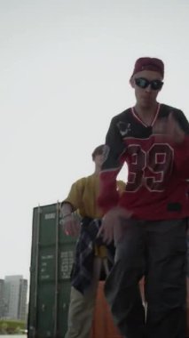 Akranlarının önünde dans eden yetenekli beyaz bir gencin el kamerası görüntüsü açık havada onu destekliyor.