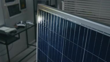 Modern yenilenebilir enerji ofisinde sunulan güneş paneli prototipinin fotovoltaik hücrelerine yakın çekim yapan kimse yok.