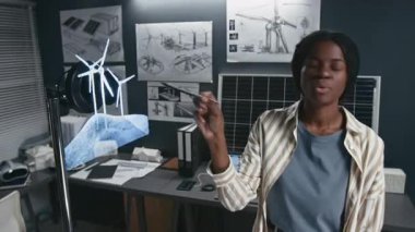 Üç boyutlu hologram LED fan kullanarak konferansta rüzgar türbinleri hakkında konuşan genç bayan alternatif enerji uzmanının göğüs yukarı çekimi, sürdürülebilir teknolojiler etkileşimli görselleştirme için