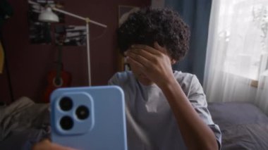 Şok olmuş öğrenci yüzünü elleriyle kapatıp akıllı telefon ekranına bakarken yanlışlıkla internetteki uygunsuz reklamları ya da olgun içerikleri gördü.