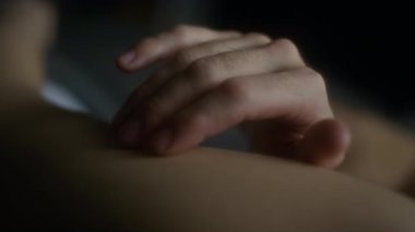 Derin bir aşk, huzur ve huzur dolu bir atmosferde erkeğin elinin aşırı yakın çekimi yumuşak ve nazikçe kadın kolunu ve omzunu okşuyor.