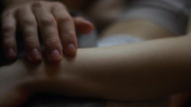 Erkek parmaklarının, kız arkadaşının soluk tenli kolunun üzerinden yavaşça koşarken yakın çekim görüntüsü, aşık çiftlerin samimi anları.
