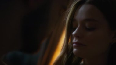 Omzunun üzerinden, uzun sarı saçlı, çekici bir bayanın nazik bir öpücük için erkek arkadaşının yüzüne yaklaşırken, özel sabahların keyfini çıkarırken, sis filtresi ve yumuşak ışık.