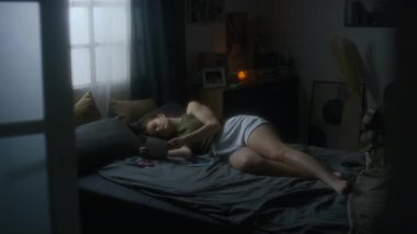 Depresyondaki genç bir kadının yatakta yatıp sevgili eski sevgilisiyle fotoğraflara bakarken, ayrıldıktan sonra acı çekerken, incinebilirlik içinde tek başına ağlarken.