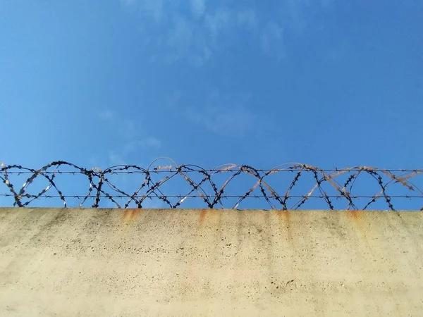 Mavi Gökyüzü Arka Planına Sahip Dikenli Tel Hapishane Duvarı — Stok fotoğraf