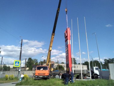 Sankt Petersburg Rusya - 05: 30 2023 Bir benzin istasyonuna beton panel bina kurulumu. İki inşaat işçisi paneli kullanıyor. Seçici odak.