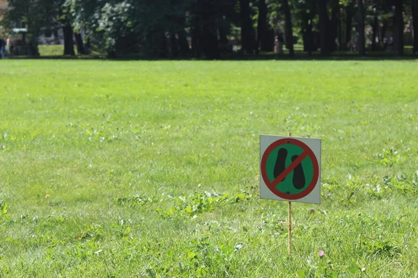 緑色のサインは 緑の草の背景に対して牧草地の領域を歩くことを禁止しています 草の上に立って 草の上に立つ人を禁じるサイン — ストック写真