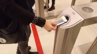 Müzeye girmek için onay makinesindeki bileti kullanan bir kadının fotoğrafını çek. Seçici odak.