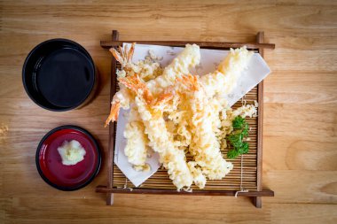 Bambu kabında servis edilen, nefis kızarmış karides tempurasının tadını çıkarın, nefis bir sosla tamamlanmış. Bu çok satan yemek fotoğrafı Asya mutfağının özünü yansıtıyor..