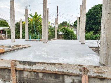 Ev inşaatı beton zemini dök ve beton sütunları dök. Arkaplanı gökyüzü.