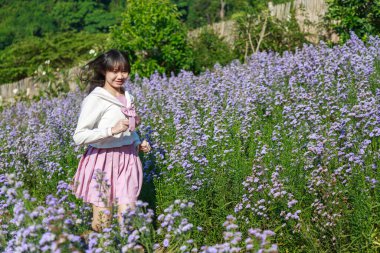 Canlı mor çiçeklerin arasında, doğanın barışçıl güzelliğini kucaklayan nazik bir an..