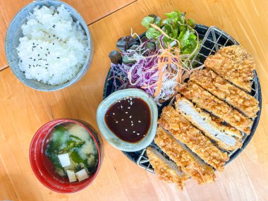 Pirinç, miso çorbası, salata ve sos ile servis edilen çıtır bir Japon domuz pirzolası.