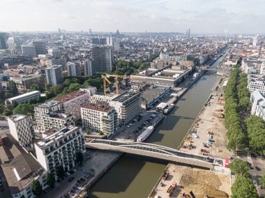 Brüksel, Belçika - 12 Mayıs 2022: Brüksel kentsel manzarası. Brüksel 'i geçen Senne nehri kanalı ve inşaat halindeki bisikletçiler ve yayalar için bir köprü. Arka planda...