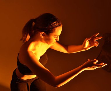 Head and shoulders close up portrait of pretty girl with expressive facial expressions, with  colourful neon gel lighting, isolated on studio background.
