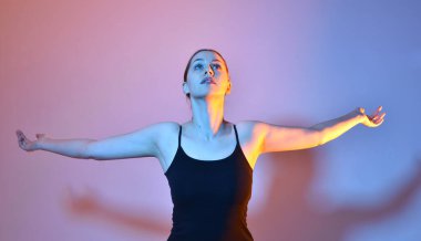 Head and shoulders close up portrait of pretty girl with expressive facial expressions, with  colourful neon gel lighting, isolated on studio background.