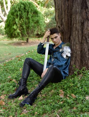  portrait of handsome brunette male model wearing fantasy medieval prince costume, romantic silk shirt, holding sword weapon.  historical castle location background with stone staircase.