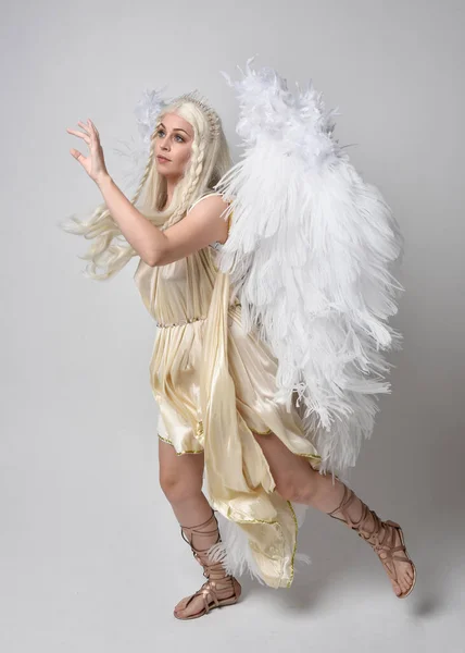 환상의 의상을 날개를 아름다운 금발의 여인의 초상화 뛰어오르는 스튜디오 배경에 — 스톡 사진