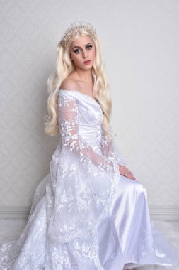 Close up portrait of beautiful women with long blonde hair, wearing white fantasy princess ball gown,  white studio background with wallpaper texture. clipart