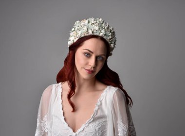 Stüdyonun arka planında zarif bir inci başlık takan güzel kızıl saçlı mankenin yakın plan portresi..