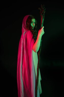 Mor fantezi pelerinli güzel esmer kadının uzun bir portresi. Elinde ahşap bir sihirbaz asası var..