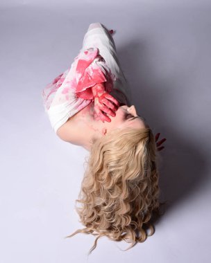  Korkunç vampir zombi gelinin portresi. Cadılar bayramı fantezi kostümü giymiş. Üzerinde kanlı kırmızı boya lekeleri var. Stüdyo arka planında izole edilmiş 