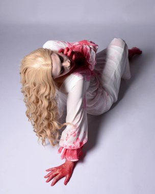  Korkunç vampir zombi gelinin portresi. Cadılar bayramı fantezi kostümü giymiş. Üzerinde kanlı kırmızı boya lekeleri var. Stüdyo arka planında izole edilmiş 