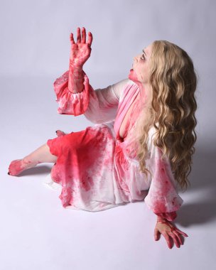  Korkunç vampir zombi gelinin portresi. Cadılar bayramı fantezi kostümü giymiş. Üzerinde kanlı kırmızı boya lekeleri var. Stüdyo arka planında izole edilmiş 