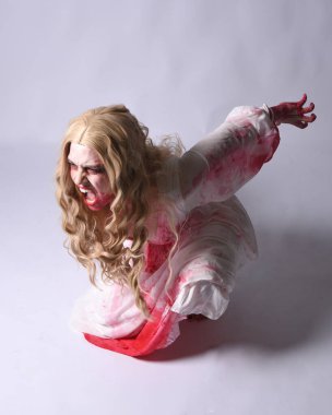  Korkunç vampir zombi gelinin portresi. Cadılar bayramı fantezi kostümü giymiş. Üzerinde kanlı kırmızı boya lekeleri var. Stüdyo arka planında izole edilmiş 