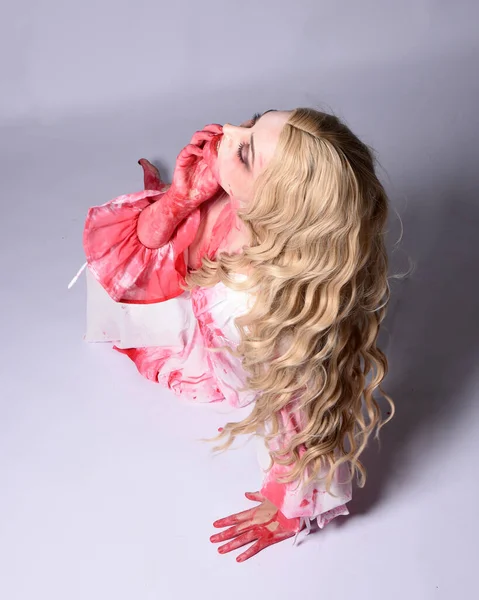  Korkunç vampir zombi gelinin portresi. Cadılar bayramı fantezi kostümü giymiş. Üzerinde kanlı kırmızı boya lekeleri var. Stüdyo arka planında izole edilmiş 