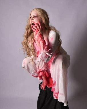  Korkunç vampir zombi gelinin portresi. Cadılar bayramı fantezi kostümü giymiş. Üzerinde kanlı kırmızı boya lekeleri var. Stüdyo arka planında izole edilmiş 