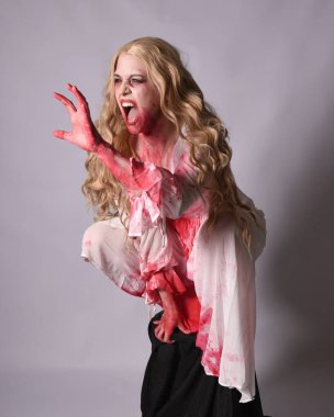  Korkunç vampir zombi gelinin portresi. Cadılar bayramı fantezi kostümü giymiş. Üzerinde kanlı kırmızı boya lekeleri var. Stüdyo arka planında izole edilmiş 