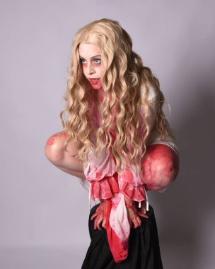  Korkunç vampir zombi gelinin portresi. Cadılar bayramı fantezi kostümü giymiş. Üzerinde kanlı kırmızı boya lekeleri var. Stüdyo arka planında izole edilmiş 