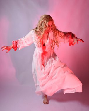 Cadılar bayramı fantezi elbisesi giymiş korkunç vampir gelin portresi. Dinamik atlama, hareketli kollar uzanıyor. Sinema kırmızı ışıklandırmalı izole stüdyo arkaplanı.