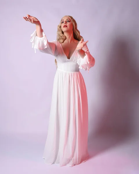 Stock image Full length portrait  of blonde woman  wearing white historical bridal gown fantasy costume dress.    Standing pose, facing forwards with gestural arms reaching out , isolated on studio background.