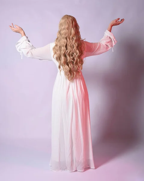 Full length portrait  of blonde woman  wearing white historical bridal gown fantasy costume dress.   Standing pose, facing backwards walking away from the camera. isolated on studio background.