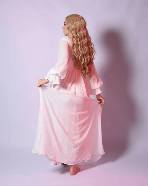 Full length portrait  of blonde woman  wearing white historical bridal gown fantasy costume dress.   Standing pose, facing backwards walking away from the camera. isolated on studio background.